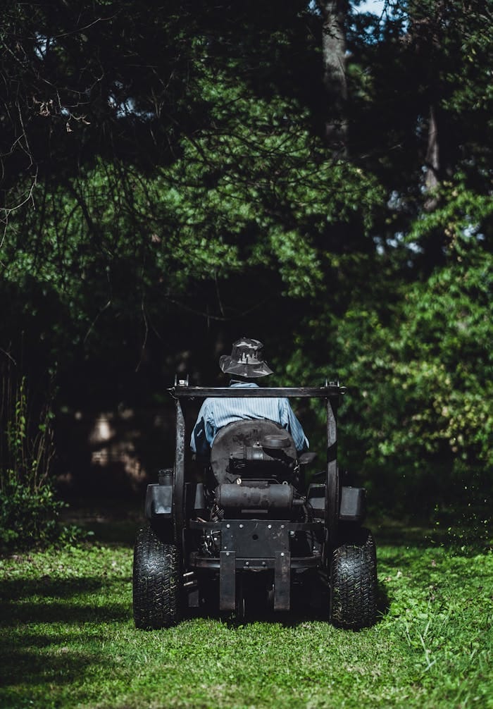 Person mowing a lush lawn with a tractor in Atlanta, GA.