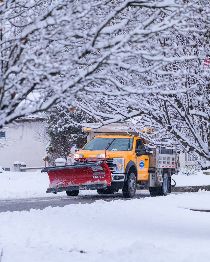 A snow plow clears a snowy residential street in Canonsburg, Pennsylvania during winter.